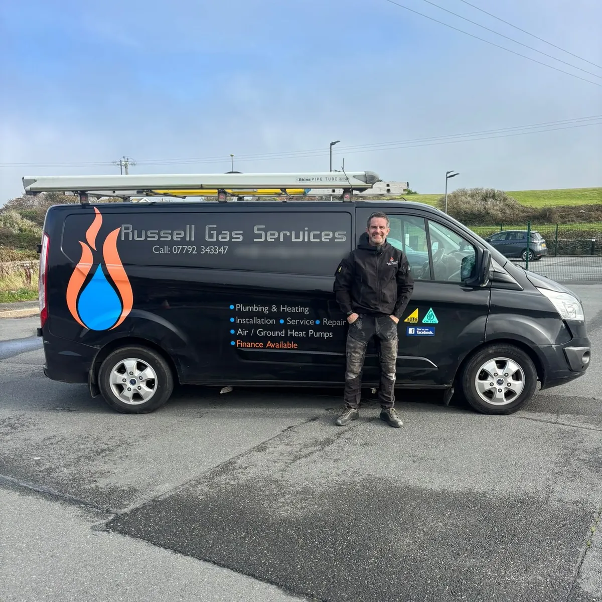 A Russell Gas Services engineer standing beside the black company van